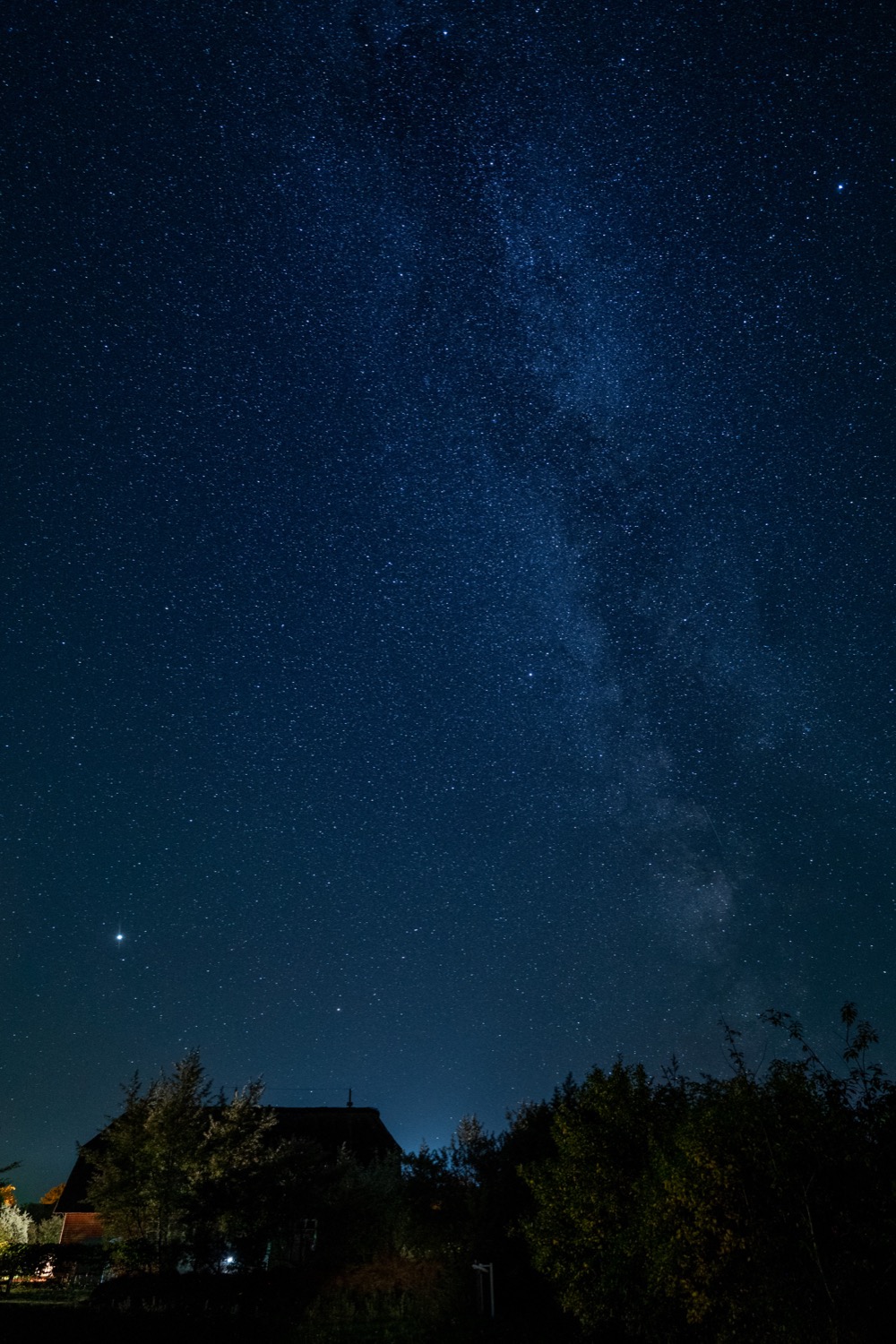 Milky Way over thatched house