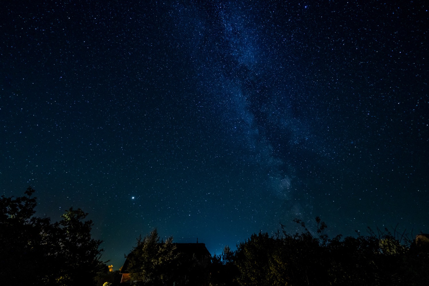 Milky Way over thatched house